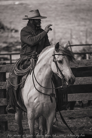 Photo of Jeff Mundell in ranch gear, riding a horse.